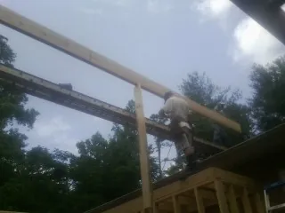 Carpenter setting a ridge beam over a new addition frame — Ice Dam Removal by Roofing Brothers in Wahoo