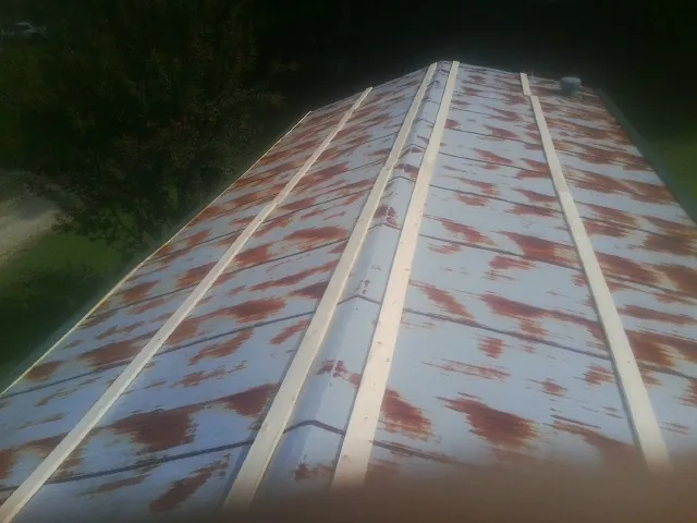 Rusted metal roof panels with new wood purlins before replacement — Storm Damage Roof Repair in Wahoo by Roofing Brothers