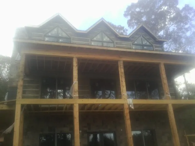 Dormers and porch framing on a large log home under construction — Roof Coating work by our crew in Wahoo