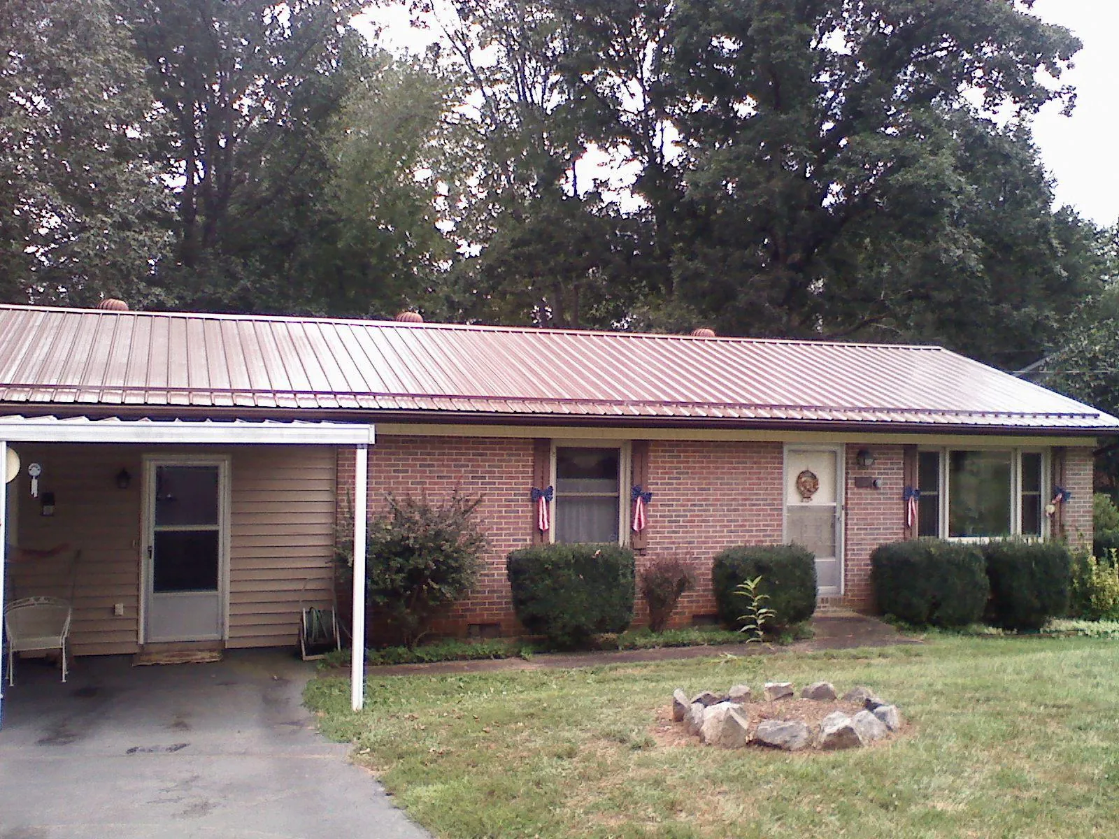 Bronze metal roof and carport on a brick ranch home — Roof Repair work by our crew in Wahoo